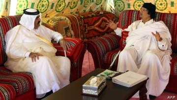 Libyan leader Moamer Kadhafi (R) talks with Qatar's Emir Sheikh Hamad bin Khalifa al-Thani while meeting in Tripoli on October 20, 2009. AFP PHOTO/MAHMUD TURKIA (Photo by MAHMUD TURKIA / AFP)