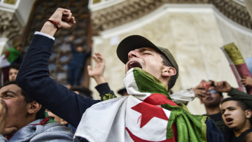TOPSHOT - Algerian students shout slogans as they demonstrate with national flags outside the Main Post Office in the centre of the capital Algiers on March 10, 2019 against ailing Algerian President Abdelaziz Bouteflika's bid for a fifth term. (Photo by RYAD KRAMDI / AFP)RYAD KRAMDI/AFP/Getty Images