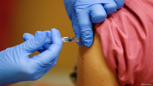 A member of the medical staff receives a flu vaccine at the department where patients suffering from the coronavirus disease (COVID-19) are treated in the Intensive Care Unit (ICU) at Havelhoehe community hospital in Berlin, Germany, October 30, 2020. REUTERS/Fabrizio Bensch