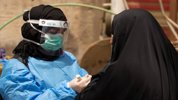 A medical worker prepares to take a swab from a woman being tested for COVID-19 coronavirus disease, in the 5-Miles district of Iraq's southern Basra on June 2, 2020. (Photo by Hussein FALEH / AFP)