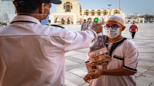TOPSHOT - A mask-clad worker measures the body temperature of incoming Muslim worshippers (COVID-19 coronavirus pandemic precaution) arriving for prayers at the Hasan II mosque, one of the largest in the African continent, in Morocco's Casablanca on June 16, 2020. (Photo by Fadel SENNA / AFP) (Photo by FADEL SENNA/AFP via Getty Images)
