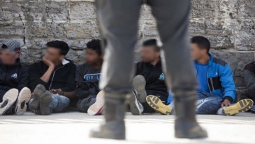 Would-be immigrants sit and rest in the port of Tarifa following their rescue by salvage vessels off the Strait of Gibraltar coast, on June 23, 2017. Eighty-eight Moroccans have been rescued today in the waters off the Strait of Gibraltar, 16 by the Salvamar Arcturus (based in Tarifa) and 72 by the Salvamar Guardamar C. Arenal (based in Tenerife). Twenty were minors. / AFP PHOTO / Marcos Moreno