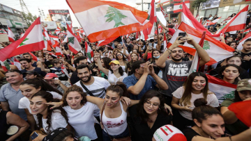 Lebanese demonstrators wave national flags on a highway linking Beirut to north Lebanon in Zouk Mosbeh on Oct. 19. JOSEPH EID/AFP via Getty Images