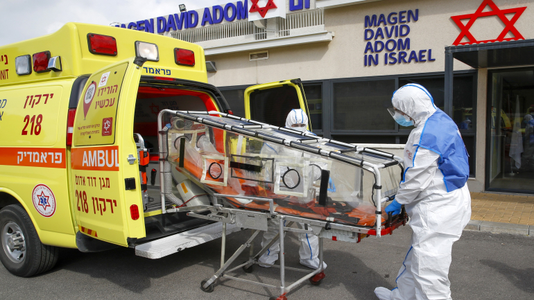 Israeli Paramedics of Maguen David Adom (Israel's National Emergency Pre-Hospital Medical Organisation) at the coronavirus national operations center unload a containment chamber during a coronavirus response training exercise in the central Israeli city of Kiryat Ono on February 26, 2020. - Some 80,000 people are infected worldwide, including nearly 2,800 outside China, and more than 2,700 have died worldwide, according to the latest toll from the World Health Organization. (Photo by JACK GUEZ / AFP)