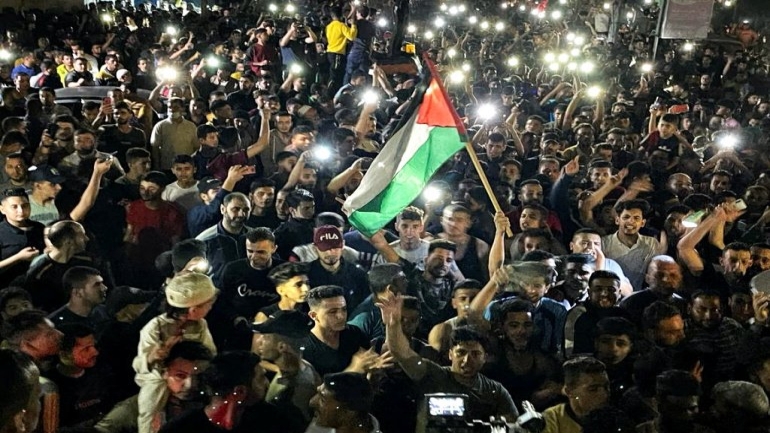 Palestinians celebrate in the streets following a ceasefire, in the southern Gaza Strip May 21, 2021. REUTERS/Ibraheem Abu Mustafa