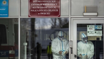 SWIECKO, POLAND - MARCH 11: Health workers wear a protective mask and suit as they wait to screen passengers temperature at near the German-Polish border on March 11, 2020 in Swiecko, Poland. Poland has introduced checkpoints at the main border crossings with Germany and the Czech Republic due to the coronavirus (COVID-19) threat. According to the World Health Organization (WHO), more than 109,000 people have been diagnosed worldwide and around 3800 have died due to the coronavirus outbreak. (Photo by Maja Hitij/Getty Images)