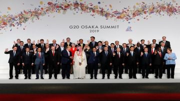 US President Donal Trump (C-L) chats with Saudi Arabia's Crown Prince Mohammed bin Salman (C-R) as other leaders wave during a family photo at the G20 Summit in Osaka on June 28, 2019. (Photo by KIM KYUNG-HOON / POOL / AFP)