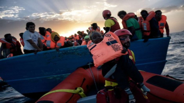 A child from African origin is rescued from a distressed vessel by a member of Proactiva Open Arms NGO in the mediteranean sea some 20 nautical miles north of Libya on October 3, 2016. Italy coordinated the rescue of more than 5,600 migrants off Libya, three years to the day after 366 people died in a sinking that first alerted the world to the Mediterranean migrant crisis. / AFP PHOTO / ARIS MESSINIS