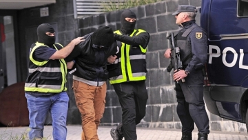 Members of the Spanish National Police escort an arrested man accused of collaborating with the Islamic State in San Sebastian on October 11, 2016.
Spanish police have arrested two men on suspicion of seeking recruits for the Islamic State group, the interior ministry said today. / AFP PHOTO / ANDER GILLENEA