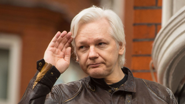 Julian Assange gestures as he speaks from the balcony of the Ecuadorian embassy in London after a seven-year investigation in Sweden against the WikiLeaks founder was suddenly dropped.