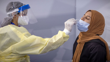 A Moroccan health worker wearing protective gear collects a nasal swab for a Covid-19 express PCR test at a centre, part of the local "smart vaccinodrome" campaign, in the Errahma district near the city of Casablanca, on August 9, 2021. - The digitalised centre aims to vaccinate 3,000 to 4,000 people per day and has its entire vaccination process through a QR code system that allows citizens to be traced throughout the vaccination circuit. (Photo by FADEL SENNA / AFP) (Photo by FADEL SENNA/AFP via Getty Images)